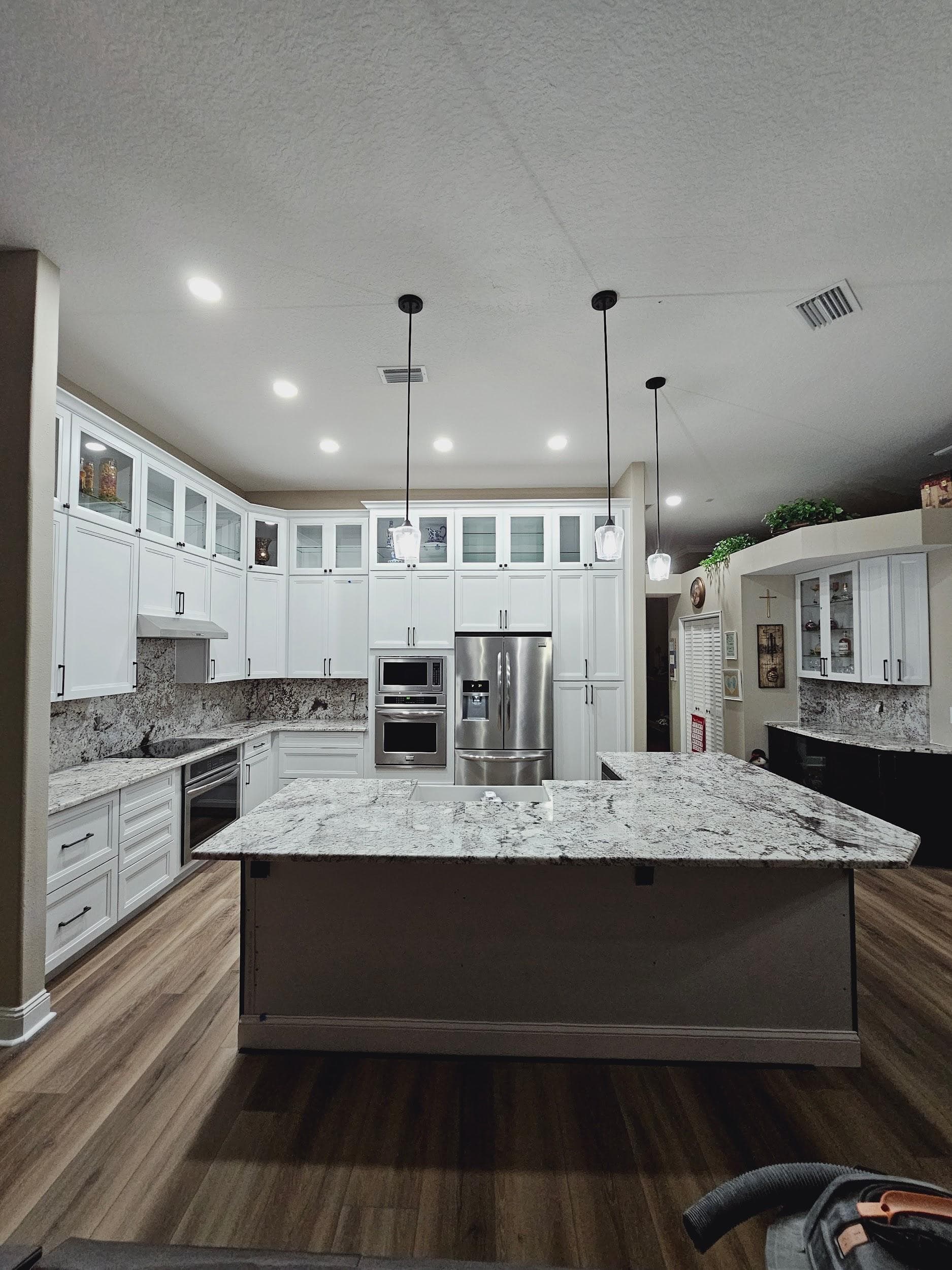 Kitchen remodeling in Dunedin FL with custom cabinets, quartz or granite countertops, backsplash, modern lighting, open concept design and new flooring
