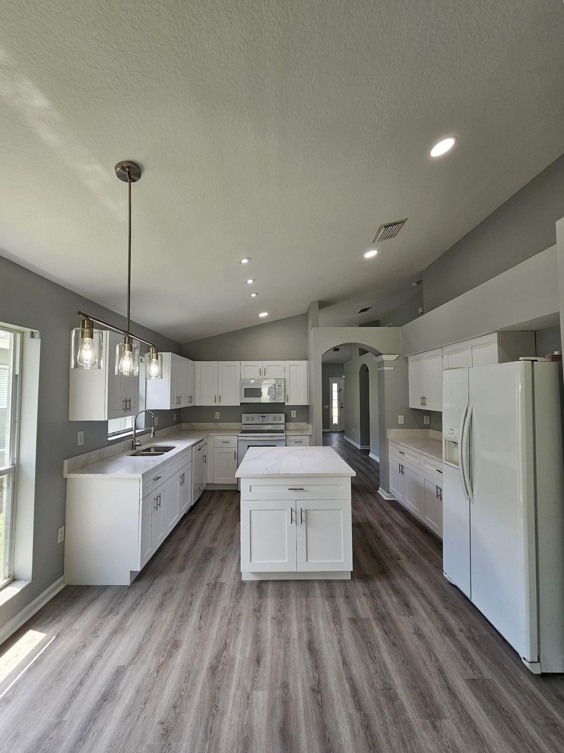 Kitchen remodeling in Wesley Chapel FL with custom cabinets, quartz or granite countertops, backsplash, modern lighting, open concept design and new flooring