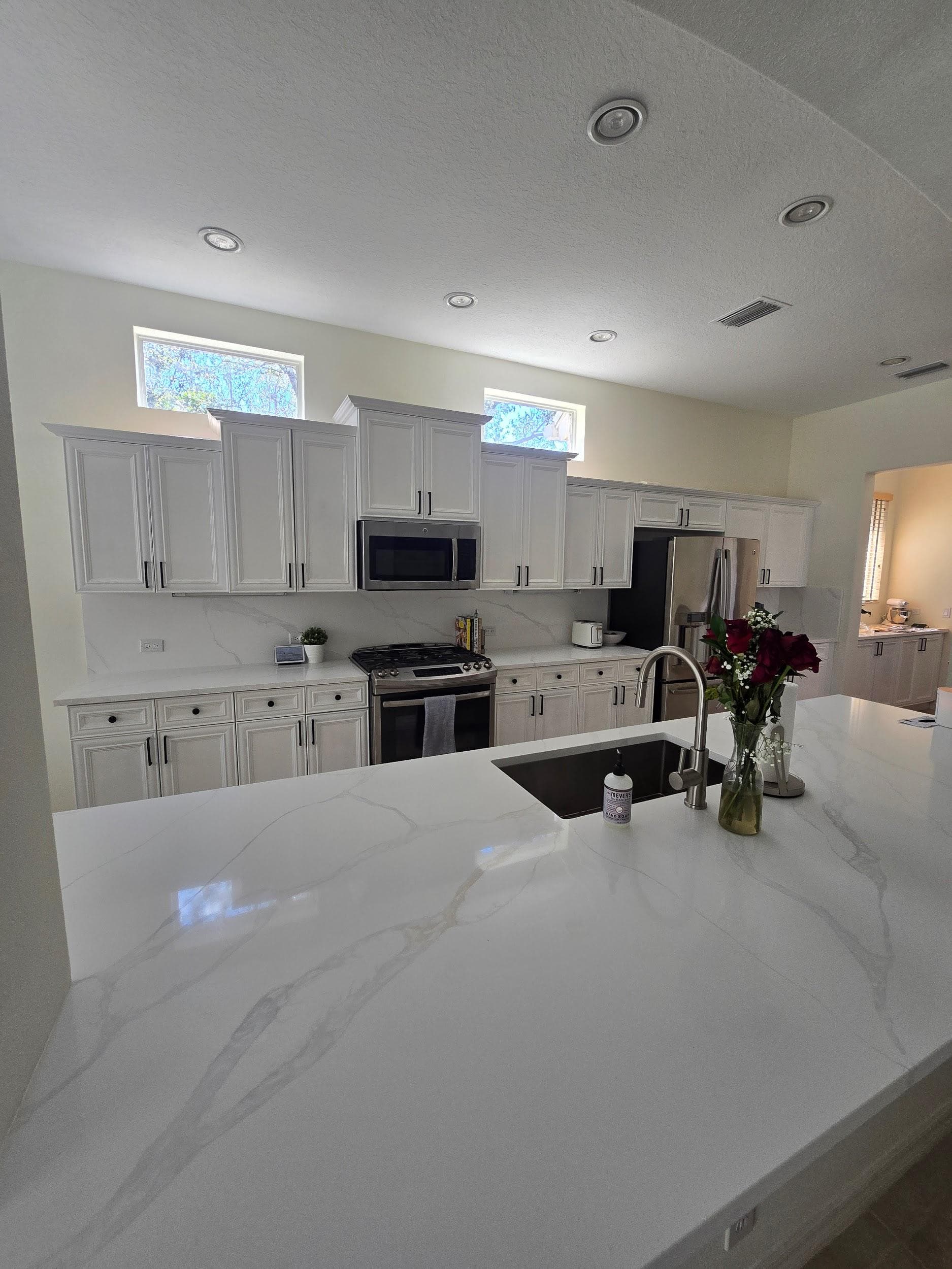 Kitchen remodeling in Apollo Beach FL with custom cabinets, quartz or granite countertops, backsplash, modern lighting, open concept design and new flooring