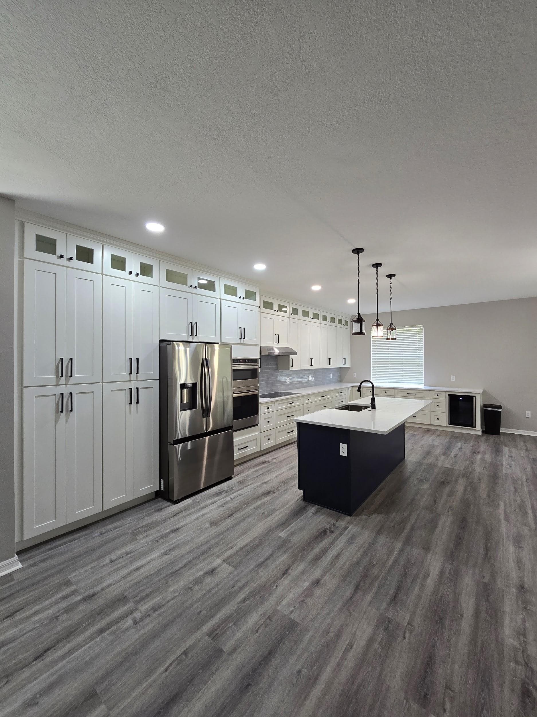 Kitchen remodeling in Land O' Lakes FL with custom cabinets, quartz or granite countertops, backsplash, modern lighting, open concept design and new flooring