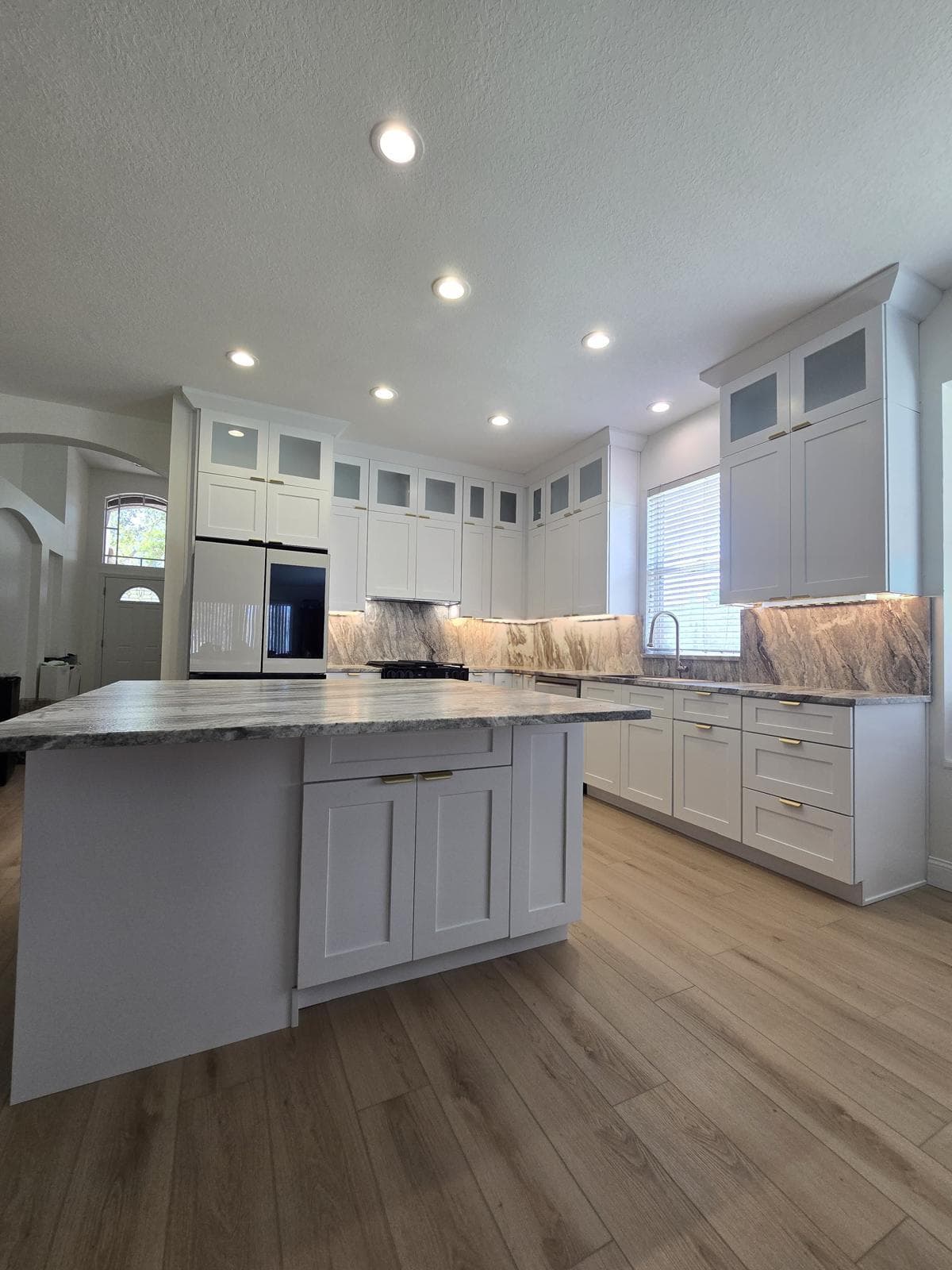 Kitchen remodeling in Tarpon Springs FL with custom cabinets, quartz or granite countertops, backsplash, modern lighting, open concept design and new flooring