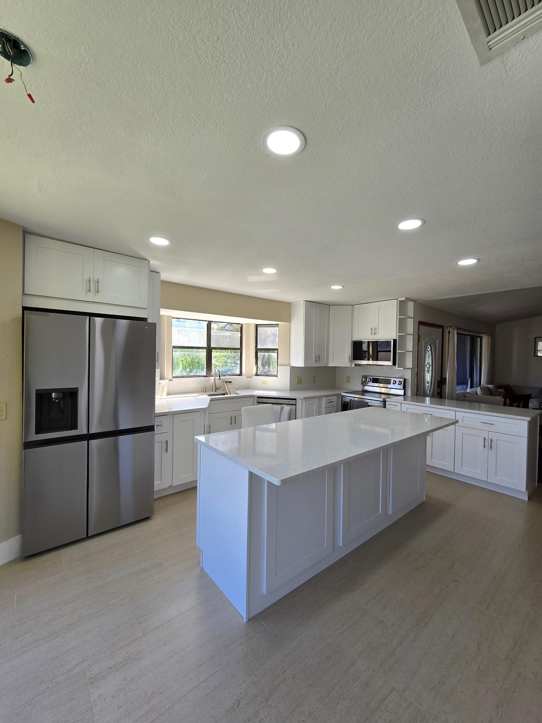 Kitchen remodeling in Odessa FL with custom cabinets, quartz or granite countertops, backsplash, modern lighting, open concept design and new flooring