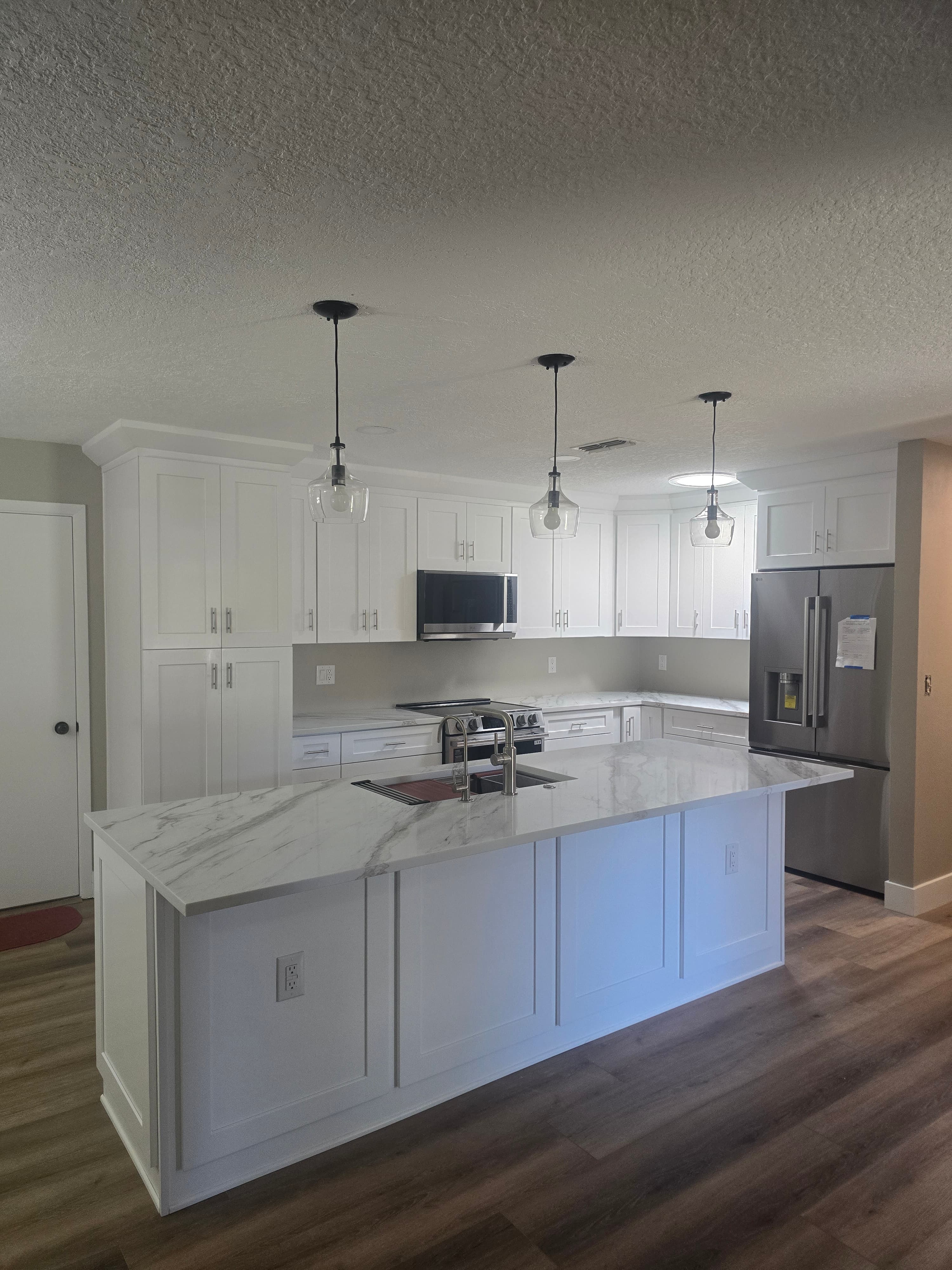Kitchen remodeling in Clearwater FL with custom cabinets, quartz or granite countertops, backsplash, modern lighting, open concept design and new flooring